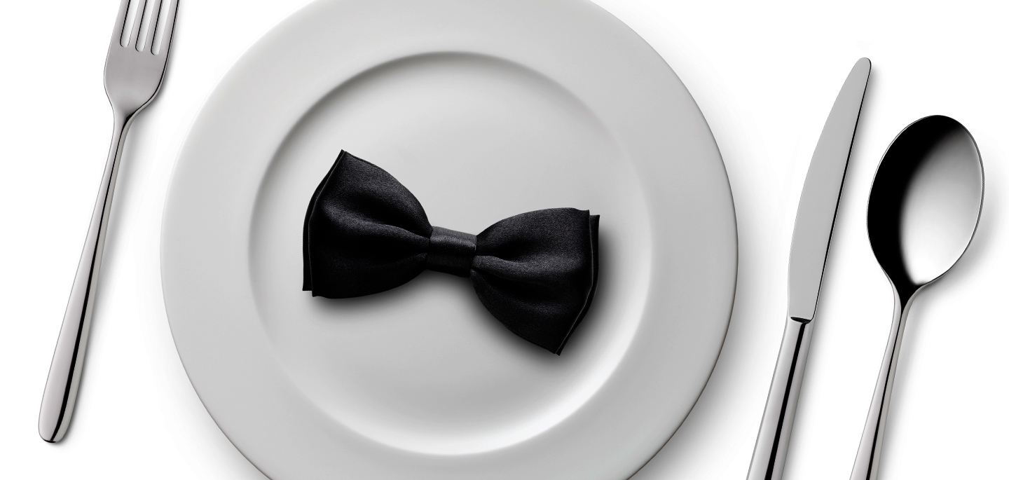 Black bow on a plate with silverware on sides