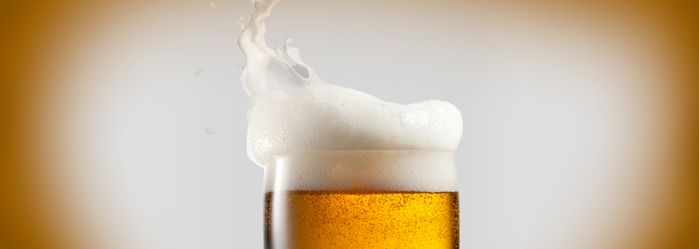 A beer with foam on top.