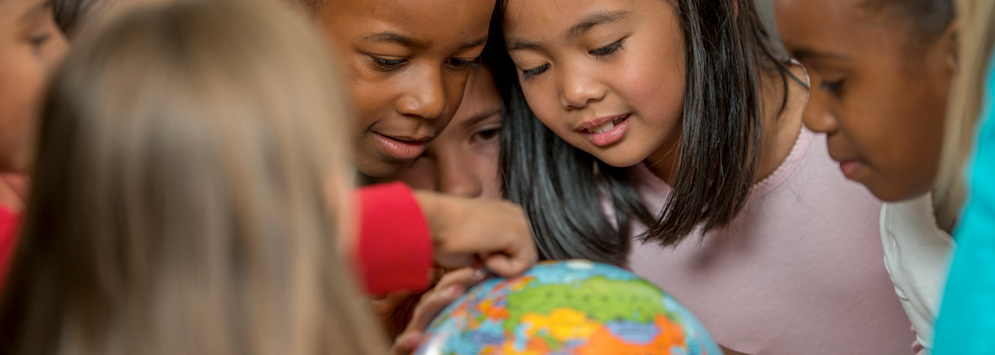 Image of students looking at a globe