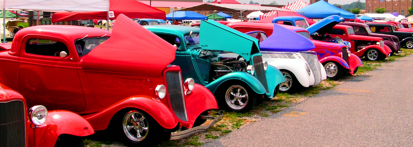 Hot rod cars with hoods open in a line