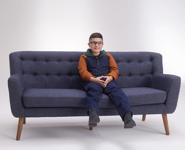 Boy sitting on blue couch