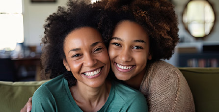 Mother and teen child hugging and smiling
