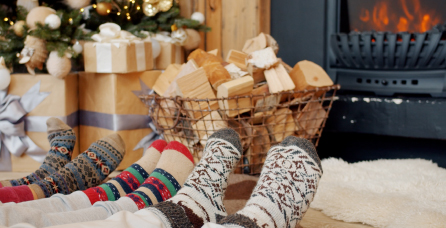 Family wearing cozy socks next to a fire.